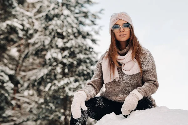 Uma Menina Uma Camisola Óculos Inverno Senta Fundo Coberto Neve — Fotografia de Stock