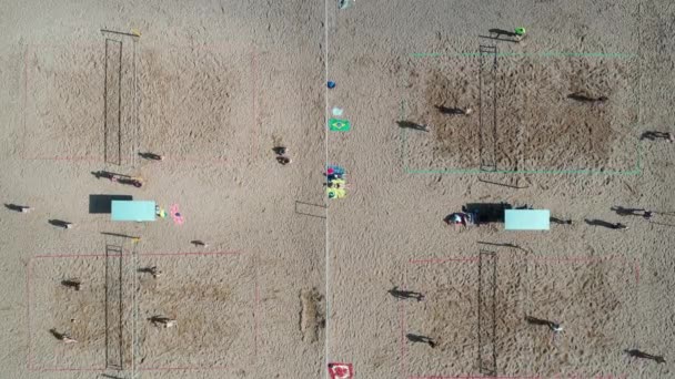 Blick von oben auf eine Gruppe von Freunden, die am Strand Beachvolleyball spielen — Stockvideo