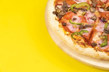 Sarı arka planda dana eti ve mantarlı lezzetli büyük pizza.
