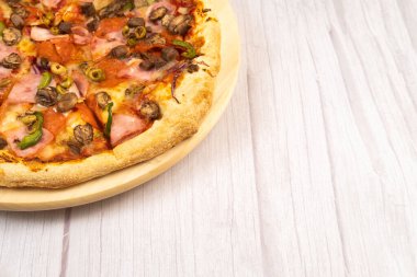 Hafif ahşap arka planda dana eti ve mantarlı lezzetli büyük pizza..