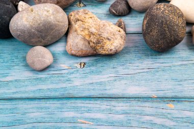 Mavi ahşap arka planda kayalar ve kabuklar. Deniz teması..