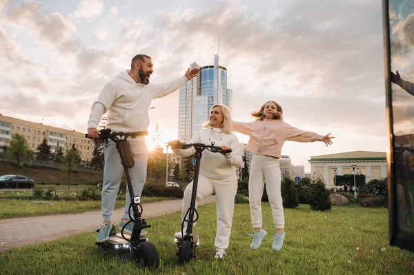 Egy Fehér Ruhás Család Áll Városban Elektromos Robogókon — Stock Fotó