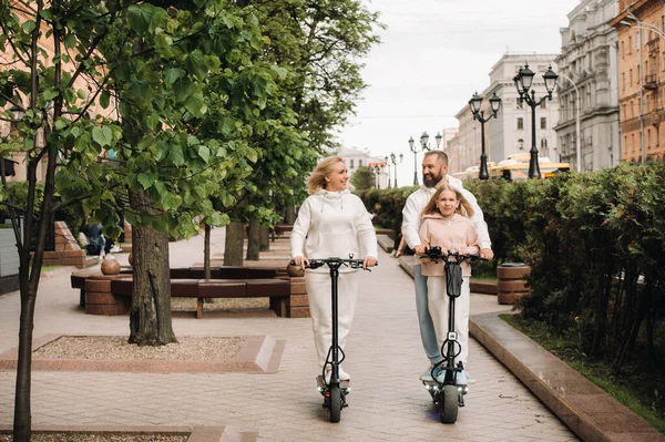 Een Familie Witte Kleren Rijdt Elektrische Scooters Stad Outdoor Activiteiten — Stockfoto