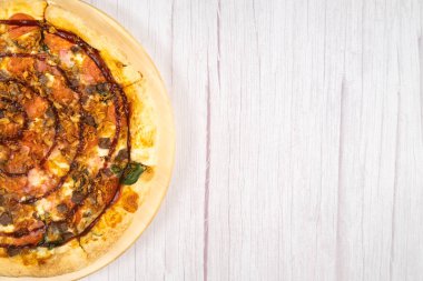 Pastırmalı ve ahşap arka planda ıspanaklı lezzetli büyük pizza..