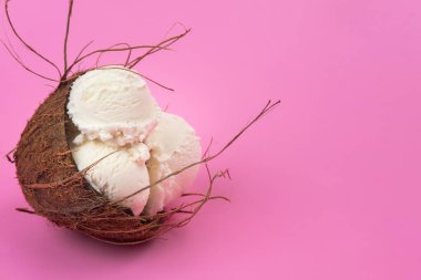 Boş hindistan cevizli vanilyalı dondurma topları. Pembe arka planda nane yapraklarıyla süslenmiş..