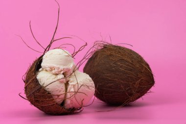 Boş hindistan cevizli vanilyalı dondurma topları. Pembe arka planda nane yapraklarıyla süslenmiş..