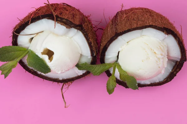 香草冰淇淋球在新鲜椰子半身装饰薄荷叶粉红背景 — 图库照片