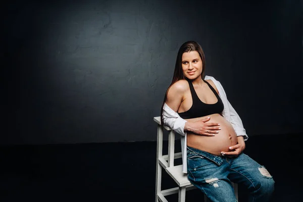 Mujer Embarazada Sentada Una Silla Escalera Estudio Sobre Fondo Negro — Foto de Stock