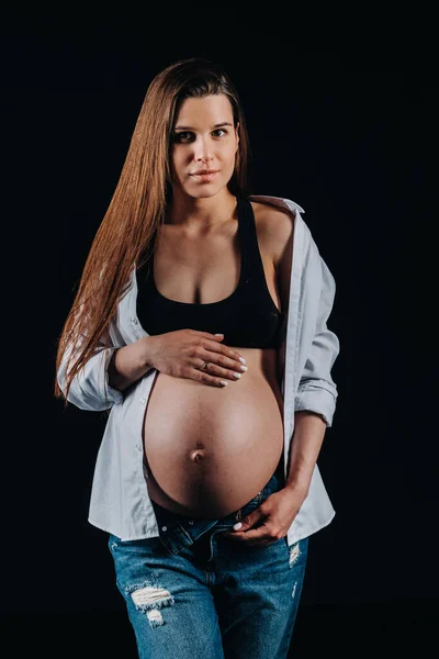 Беременная Женщина Белой Рубашке Джинсах Студии Черном Фоне — стоковое фото