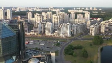 Günbatımında Belarus Cumhuriyeti 'nin başkenti Minsk' te bir parka sahip olan Ulusal Kütüphane 'nin ve yeni küçük bölgenin en üst görüntüsü, bir kamu binası.