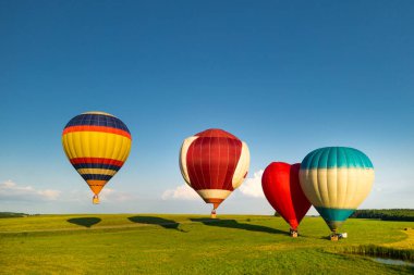 İnsanlarla dolu balonlar sahada havalanmaya hazır..