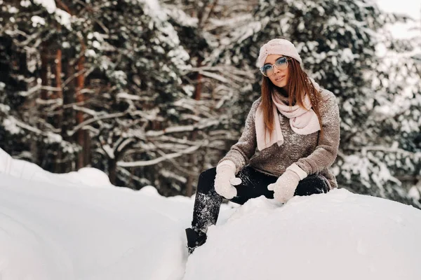 Uma Menina Uma Camisola Óculos Inverno Senta Fundo Coberto Neve — Fotografia de Stock