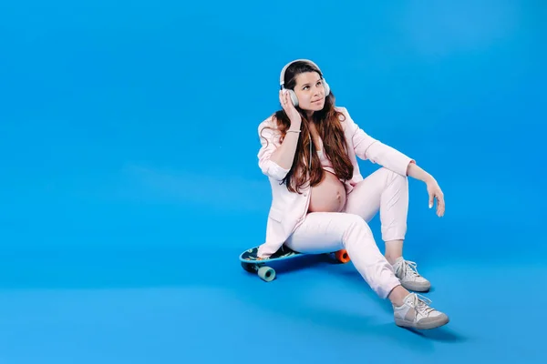 Een Zwangere Vrouw Een Roze Pak Zit Een Skateboard Met — Stockfoto