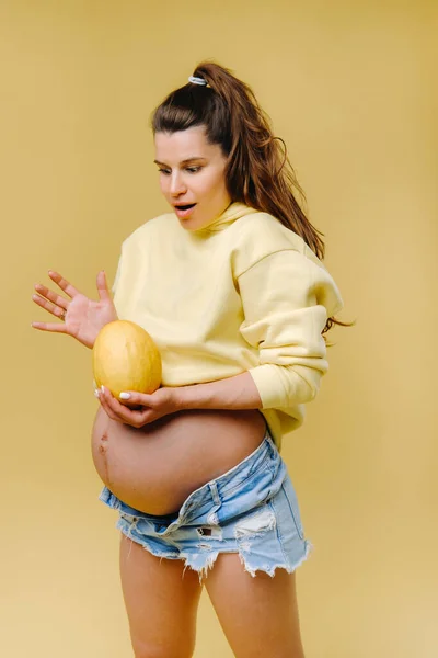 Una Embarazada Con Una Chaqueta Amarilla Está Pie Con Melón — Foto de Stock