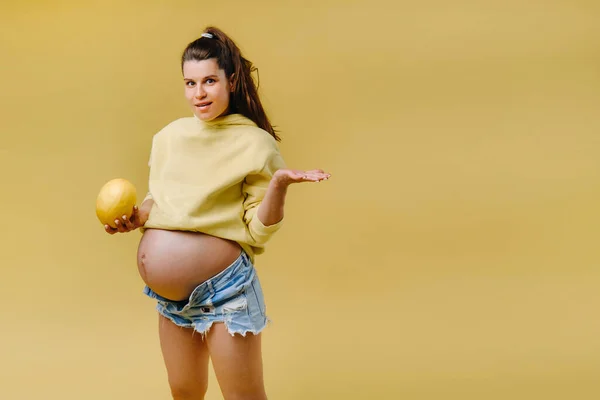 Una Embarazada Con Una Chaqueta Amarilla Está Pie Con Melón — Foto de Stock