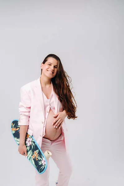 Een Zwanger Meisje Een Roze Pak Met Een Skateboard Haar — Stockfoto