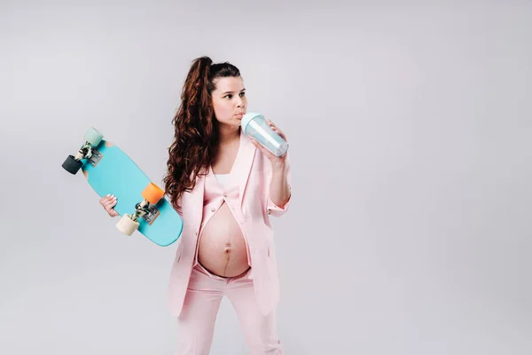 Een Zwanger Meisje Een Roze Pak Met Een Skateboard Haar — Stockfoto