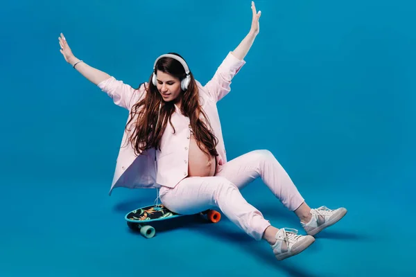 Een Zwangere Vrouw Een Roze Pak Zit Een Skateboard Met — Stockfoto