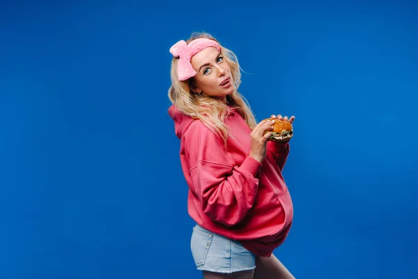 Een Zwanger Meisje Roze Kleren Met Een Hamburger Haar Handen — Stockfoto