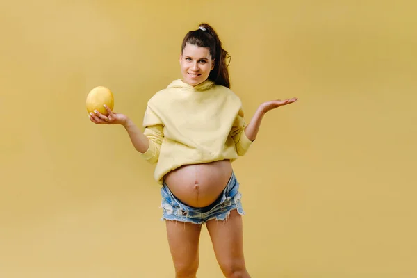 Uma Menina Grávida Com Uma Jaqueta Amarela Fica Com Melão — Fotografia de Stock