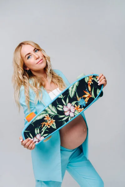 Pregnant Girl Turquoise Clothes Skateboard Her Hands Gray Background — 图库照片