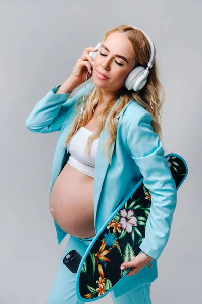 Una Chica Embarazada Con Traje Turquesa Con Monopatín Las Manos — Foto de Stock