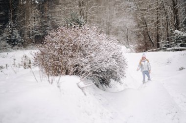 Kışın gümüş ceketli küçük bir kız kışın dışarı çıkar..