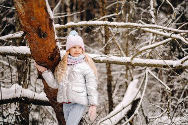 Kışın gümüş ceketli küçük bir kız kışın dışarı çıkar..
