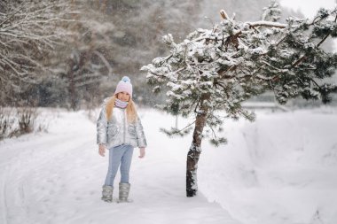 Kışın gümüş ceketli küçük bir kız kışın dışarı çıkar..
