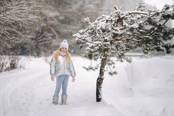 Kışın gümüş ceketli küçük bir kız kışın dışarı çıkar..