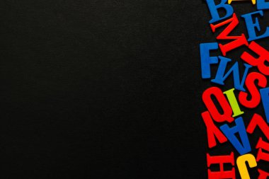 Siyah arkaplanda çok renkli harfler var. Anaokulu okuma talimatları. Alfabeyi öğreniyorum.