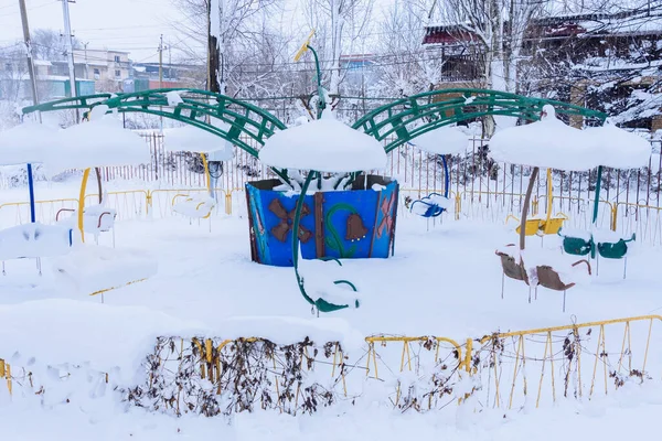 Çocukların salıncağı karda. Kış mevsiminde salıncakta kimse olmaz. Kar fırtınası bebeği sarstı.