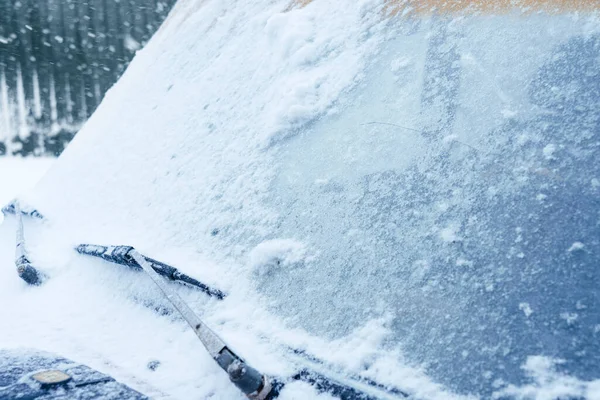 Karda araba silecekleri. Yolda kar yağışı. Arabanın camı karla kaplıydı. Silecekler kar temizleyemez. Otomatik ön cam kreması.