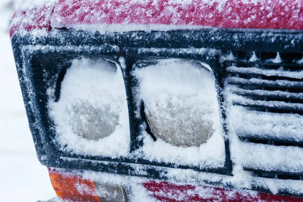 Arabanın farları karla kaplıydı. Araba farlarının buzlanması.