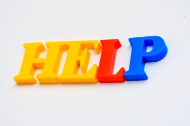 Beyaz arkaplanda renkli harflerle yazıtlara yardım et. Yakın plan..