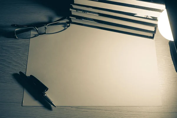 Yukarıdan bak. Boş kağıt, kalem, bardak, kitap yığını. Hatırlatma, mektup, not