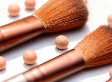 Makyaj fırçalarının arasında top şeklinde makyaj kızarıklığı var. Beyazı izole et.