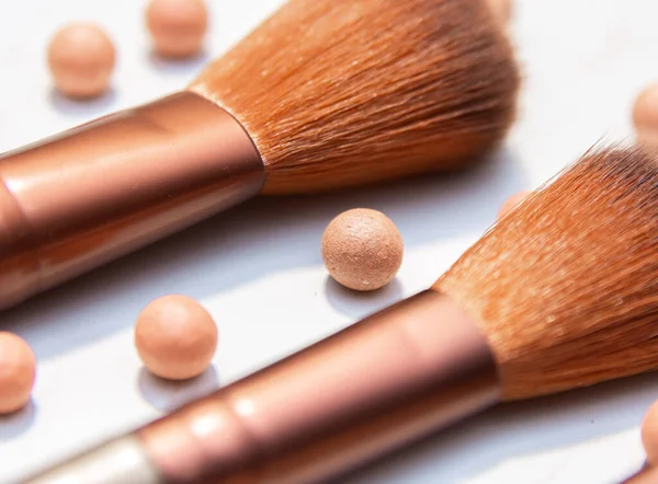 Pudralı inciler. İki makyaj kimonosu ve bir pudra topu. Beyazı izole et. Profesyonel makyaj malzemeleri.