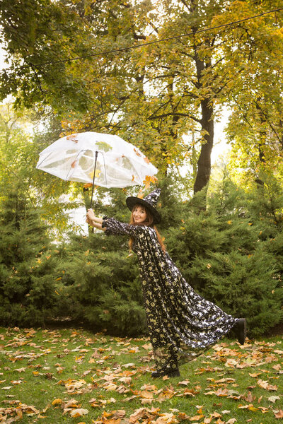 Halloween. Beautiful young woman in a festive mood at a Halloween picnic. Warm autumn October day. Emotion concept.