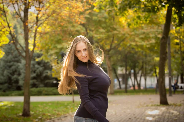 美丽的年轻女子 背景是秋天的树木 情感概念 走在秋天的公园里 背光射击 — 图库照片