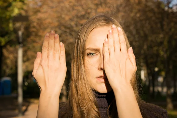 秋の木々の背景に美しい若い女性 感情の概念 少女は彼女の顔を手で覆う — ストック写真