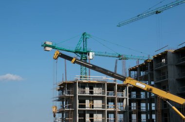 Bina. Mavi gökyüzüne karşı bir inşaat vincinin yakın çekimi.