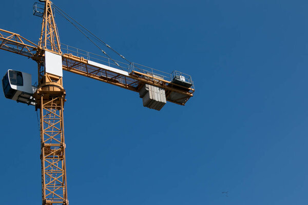 Building. Close-up of a construction crane against the blue sky.