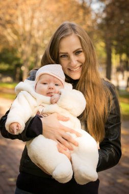 Anne ve kızı sonbahar parkında. Duygu konsepti. Arka plan çekimi.