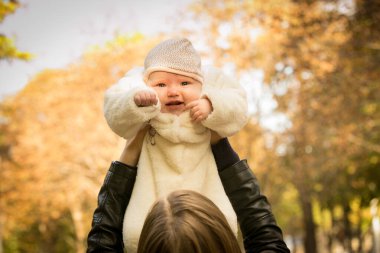 Düş! Sonbahar sarı yapraklı arka planda yeni doğmuş bir bebek. Annemin elleri. Arka plan çekimi.