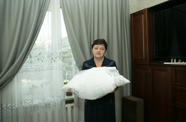 Ev ödevi. Orta yaşlı bir kadın yeni yatak örtüsü takıyor..