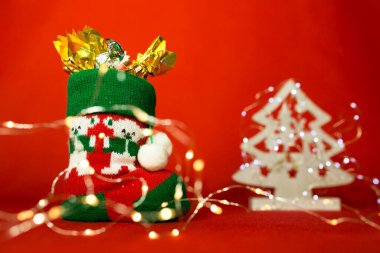 Kırmızı arka planda yeni yıl ve yılbaşı kartı. Şekerli botlar ve Noel ışıkları. Aziz Niklas Günü için içerik.