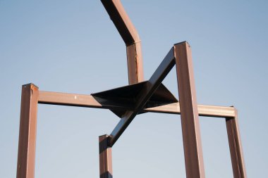 Mavi gökyüzüne karşı metal yapı. Paslı pullu metal.