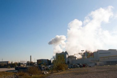 Kimya fabrikasının bacasından dumanlar yükseliyor. Ekoloji teması.