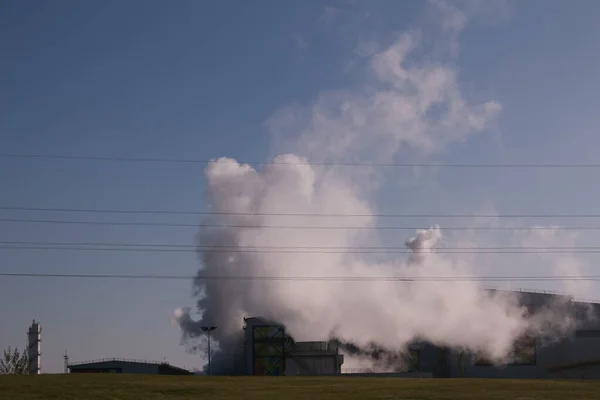 Smoke from chemical factory chimney on cloudy sky background. Ecology theme.